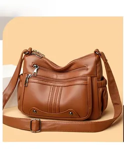 Détails de la texture du cuir grainé marron et des fermetures éclair sur ce sac à main