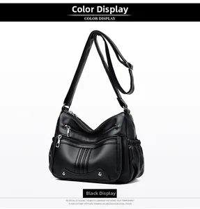 Gros plan sur un sac bandoulière en cuir souple noir avec plusieurs zips et texture grainée