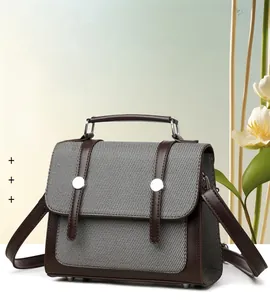 Dettaglio della borsa vintage a righe con finiture in pelle marrone e fibbie