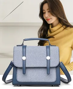 Dettaglio della borsa a tracolla a righe con fibbie argento e finiture in pelle blu