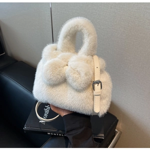 Detail showing plush white faux fur texture and matching bow with adjustable leather strap