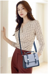 Dettaglio borsa a patta in tessuto grigio-blu e pelle navy con borchie argento e manico