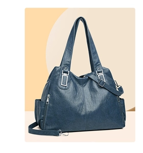 Dettaglio borsa tote blu scuro con texture litchi, hardware argento e zip laterali