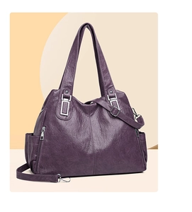 Dettaglio di una borsa tote in ecopelle viola scuro con trama vintage e zip argentate