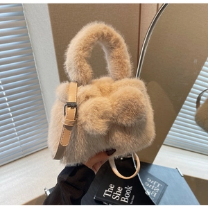 Detail of plush beige bucket bag with a large bow, faux fur texture and leather strap