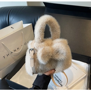 Detail of plush beige faux fur bucket bag with adjustable faux leather shoulder straps