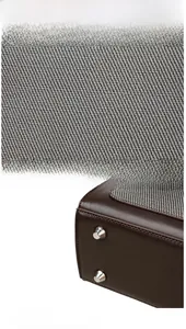 Dettaglio di tessuto twill grigio e fondo in pelle marrone con borchie protettive argento