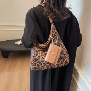 Grande borsa shopper leopardata con tracolla in pelle e pochette indossata da modella