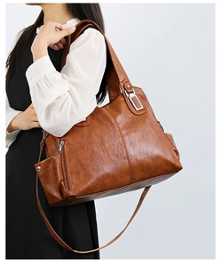 Dettaglio borsa tote marrone in ecopelle con trama a grana fine e fibbie metalliche argentate