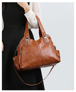 Dettaglio borsa tote in morbida pelle marrone con trama vintage e cerniere argentate