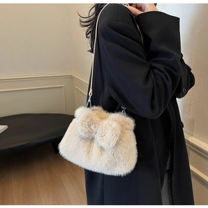 Detail of plush beige bucket bag with cute bear ears and silver metal strap hooks