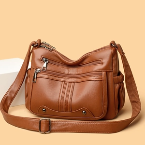 Sac bandoulière en cuir marron foncé avec plusieurs poches zippées et sangle large