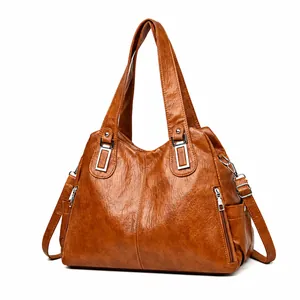 Dettaglio borsa tote in pelle cerata marrone con finiture argentate e zip laterale