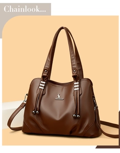 Detail of dark brown lychee grain leather tote bag with metal kangaroo logo and tassels