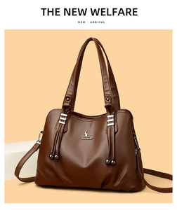 Close-up of dark brown lychee pattern leather tote with metal kangaroo logo and tassels