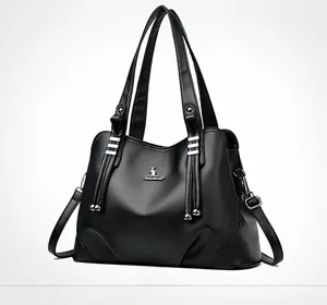 Detail of black pebbled leather tote bag with silver kangaroo logo and adjustable strap