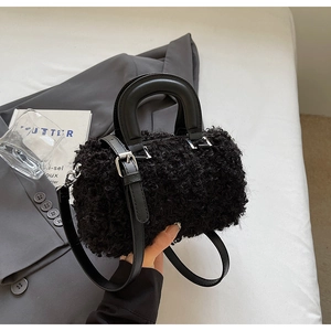 Detail of black faux fur Boston bag showing curly fleece texture and leather strap