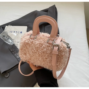 Gros plan du mini sac rose en laine d'agneau avec poignée en cuir lisse et zip argenté