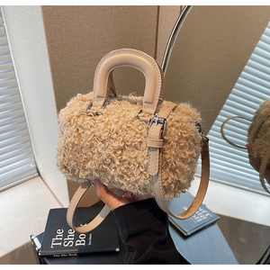 Close-up of beige fleece crossbody bag with smooth leather handles and silver hardware