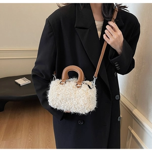Détail du mini sac boîte en polaire blanche avec poignées en cuir marron et boucles argent