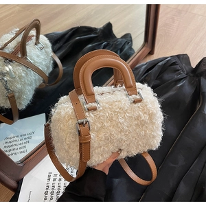 Macro view of plush cream faux fur texture and brown leather handle with silver metal buckles