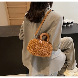 Détail du sac boîte en polaire kaki foncé avec poignées en cuir porté par un mannequin
