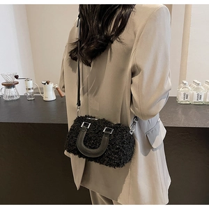 Detail of black faux shearling pillow bag showing soft texture and leather strap