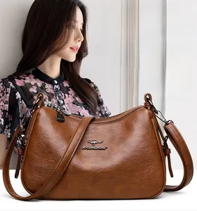 Close-up of brown faux leather shoulder bag with metallic hardware and adjustable strap