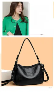Detail of black leather crossbody bag featuring silver kangaroo logo and refined texture