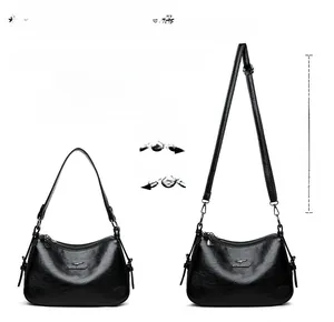 Detail of black crossbody bag featuring dual detachable straps and adjustable metal buckle