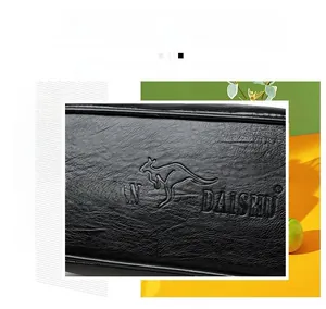 Close-up of black lychee grain leather texture with embossed kangaroo logo on a handbag