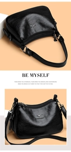 Close-up of black leather crossbody bag with metallic zipper details and logo charm