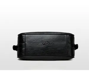 Detail of lychee-textured black faux leather bag base with embossed kangaroo brand logo