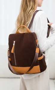 Brauner Wildleder-Rucksack mit karamellfarbenen Riemen und Seitentaschen am Modell