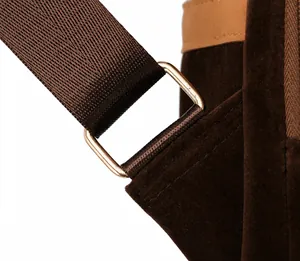 Details der goldenen Metallschnalle am dunkelbraunen Wildlederrucksack mit Webriemen