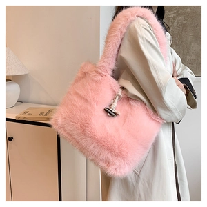 Pink faux fur tote bag with toggle closure and shoulder strap shown on model side view
