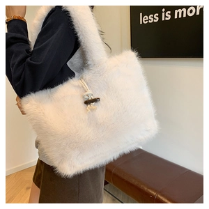 Detail view of large white faux fur tote bag with wooden horn buckle and woven knot detail