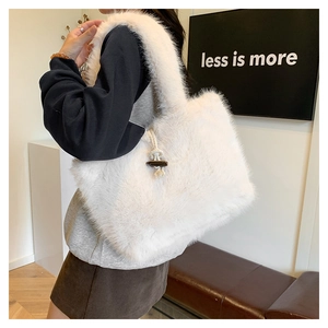 Detail of white faux fur tote bag showing wooden toggle closure and woven cord texture