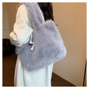 Detail view of a large fluffy faux fur tote bag in pale purple-grey with side knot accent