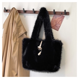 Detail of black faux fur tote bag featuring white cotton rope and wooden toggle closure