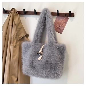 Detail of grey plush tote bag featuring braided rope and dark toggle button closure
