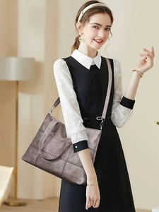 Close-up of deep brown tote bag with square stitching and detachable shoulder strap