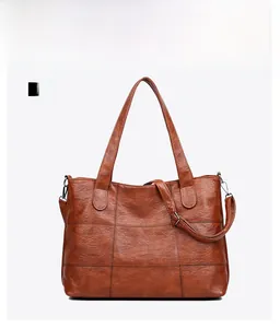 Detailed front view of brown textured tote bag with top handles and adjustable strap
