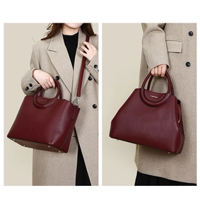 Detail of burgundy tote bag with woven handles and studs shown in crossbody and handheld style
