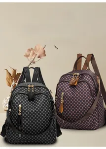Detail view of water-resistant geometric print backpacks in black and brown with gold zippers