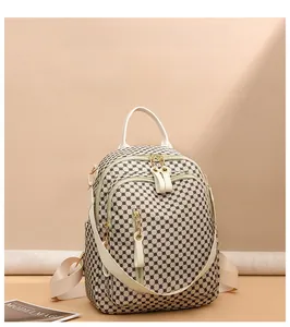 Detailed view of beige vintage backpack with circular grid pattern and gold zippers