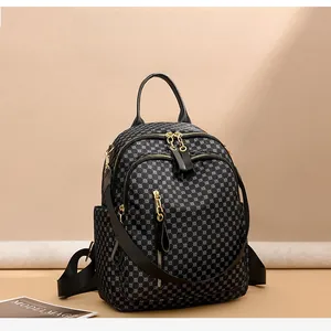 Detail view of vintage printed backpack showing golden zippers and geometric dot patterns