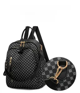 Detail of floral print backpack featuring gold-tone dual zippers and detachable metal hooks