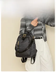 Detail showing vintage geometric pattern travel backpack with gold zippers and multi-way strap
