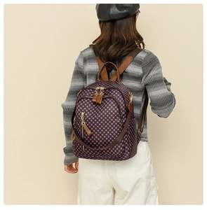 Detail of vintage checkered backpack featuring waterproof fabric and gold zippers on model